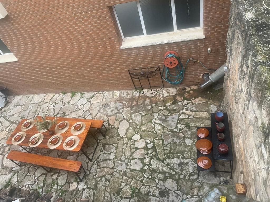 Una vista aérea de un patio de piedra con una mesa y bancos.