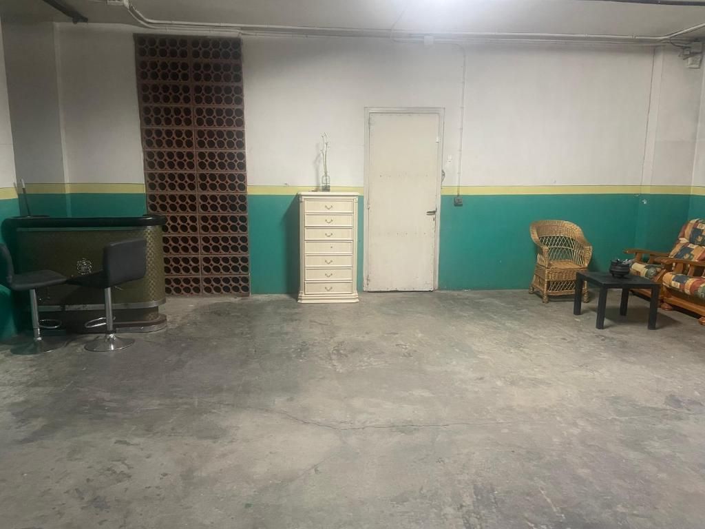 Una sala de estar con un sofá, sillas, mesas y una puerta.