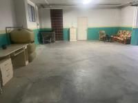 Una gran habitación vacía con un sofá, un escritorio y sillas.