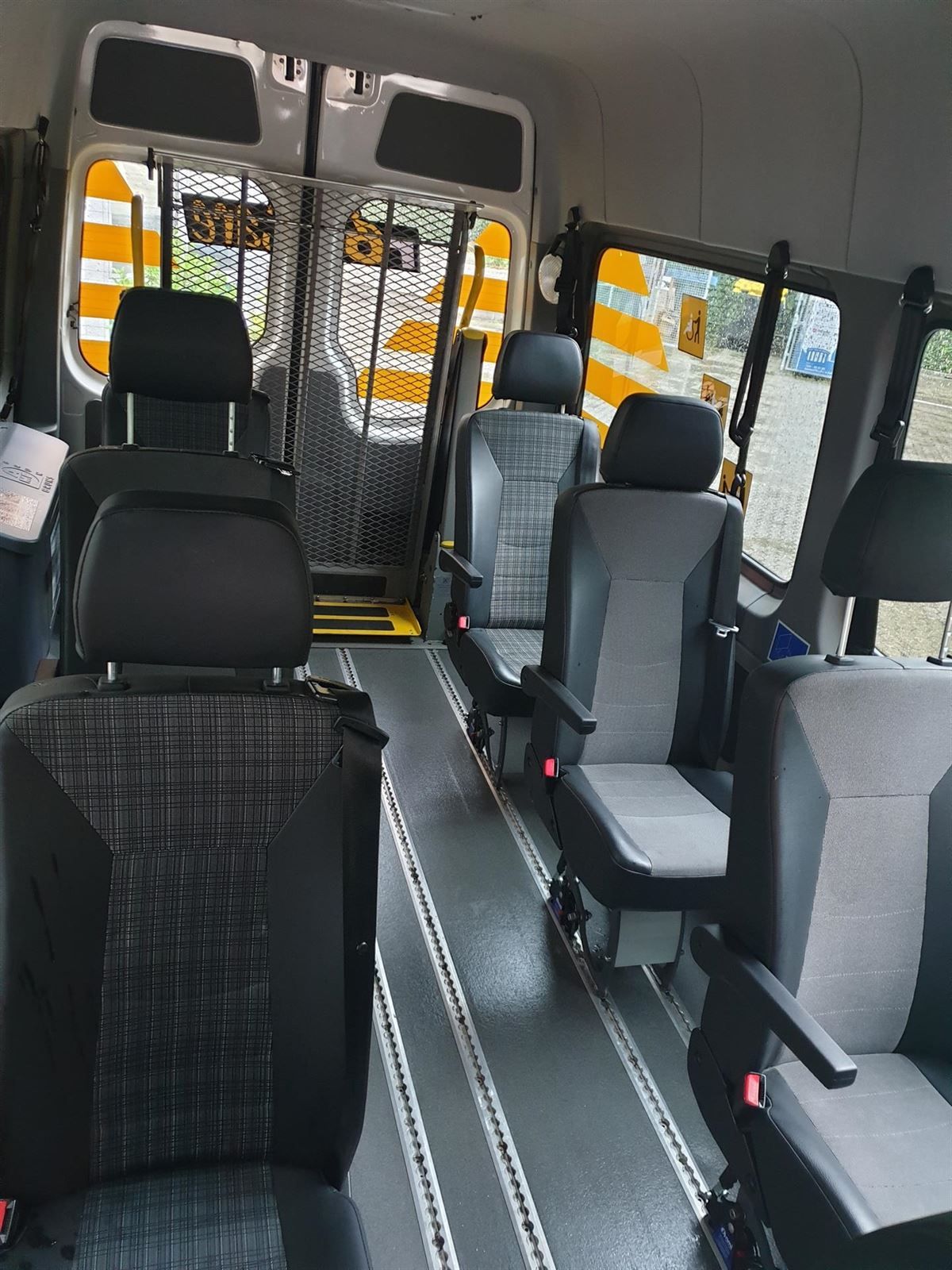 Eine Sitzreihe in einem Lieferwagen mit einem Schild mit der Aufschrift „Notausgang“ darauf