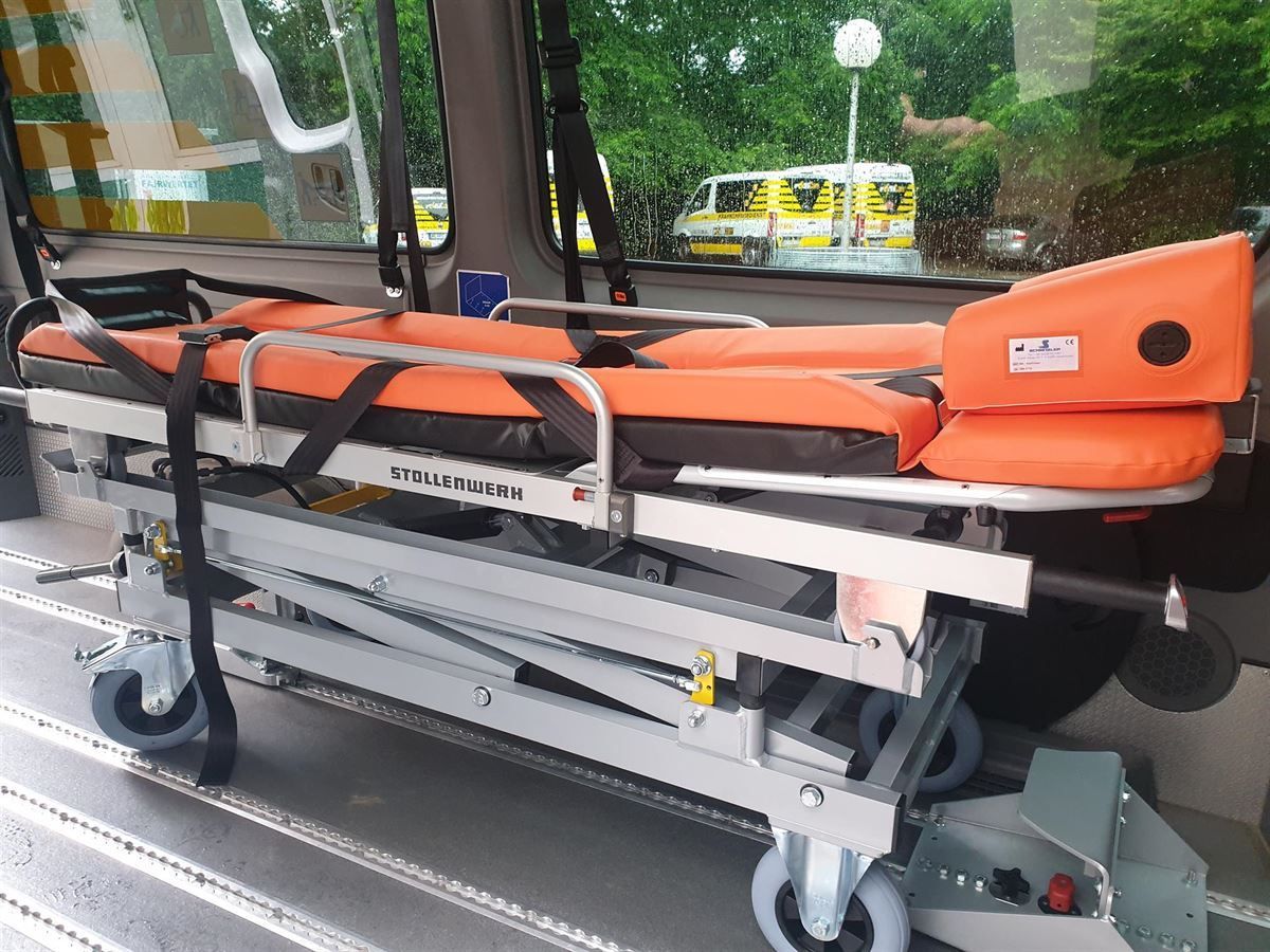 Eine orangefarbene Trage liegt im hinteren Teil eines Krankenwagens