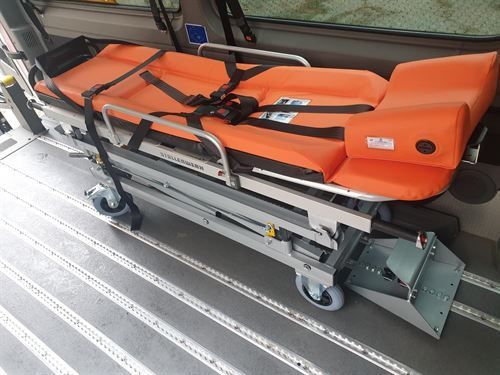 Auf dem Rücksitz eines Autos steht eine orangefarbene Trage.