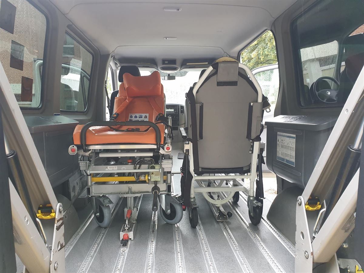Ein Krankenwagen und ein Rollstuhl befinden sich auf der Ladefläche eines Lieferwagens