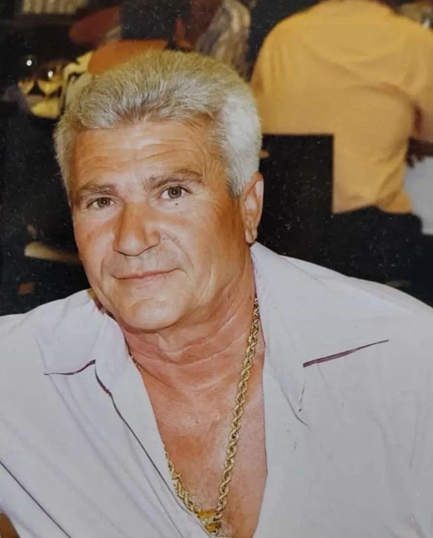 Un hombre con sombrero de vaquero ajusta las bridas de su caballo; ambos están al aire libre. Foto en blanco y negro.
