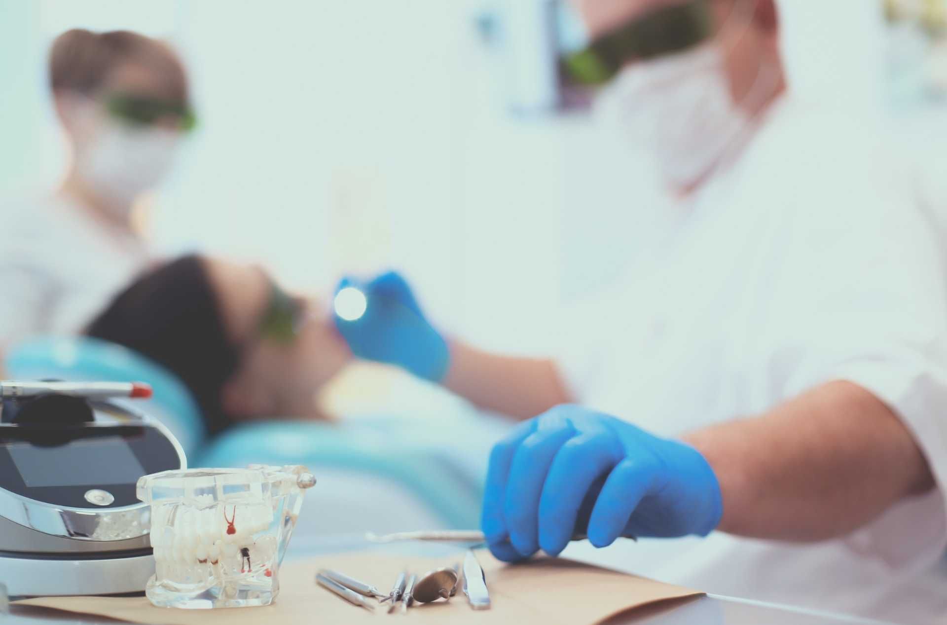 Un dentista está examinando los dientes de un paciente en un consultorio dental.
