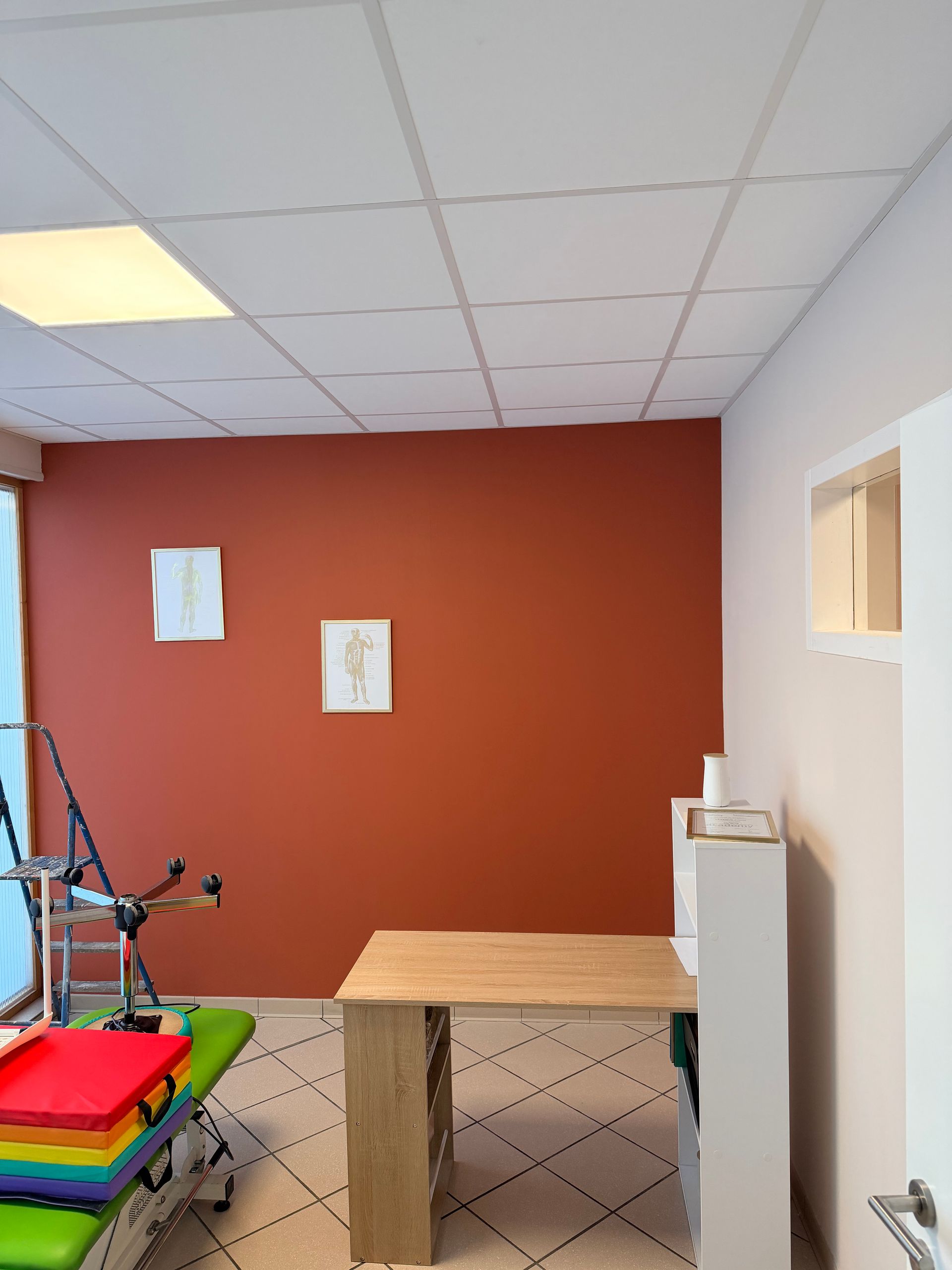 Un peintre en bâtiment repeint un mur intérieur