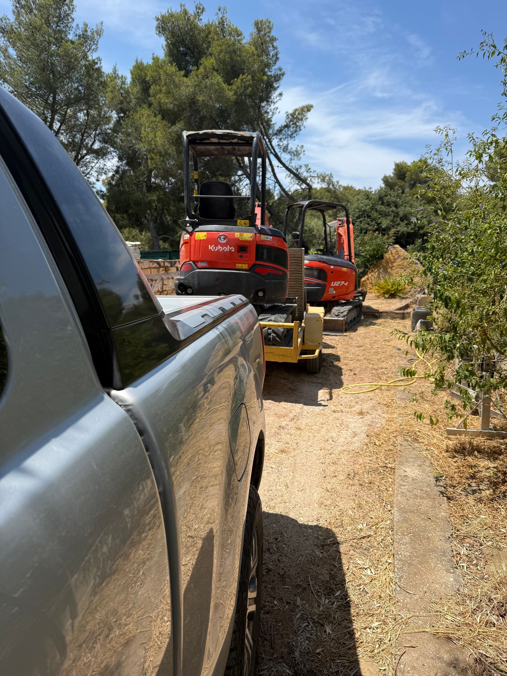 Une minipelle sur une remorque qui se fait tracter
