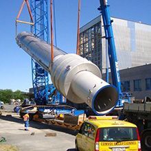 Um grande cano está sendo levantado por um guindaste.