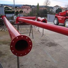 Um monte de canos vermelhos estão sobre uma mesa em um estacionamento.