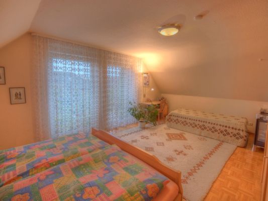 Ein Schlafzimmer mit zwei Betten und einem großen Fenster