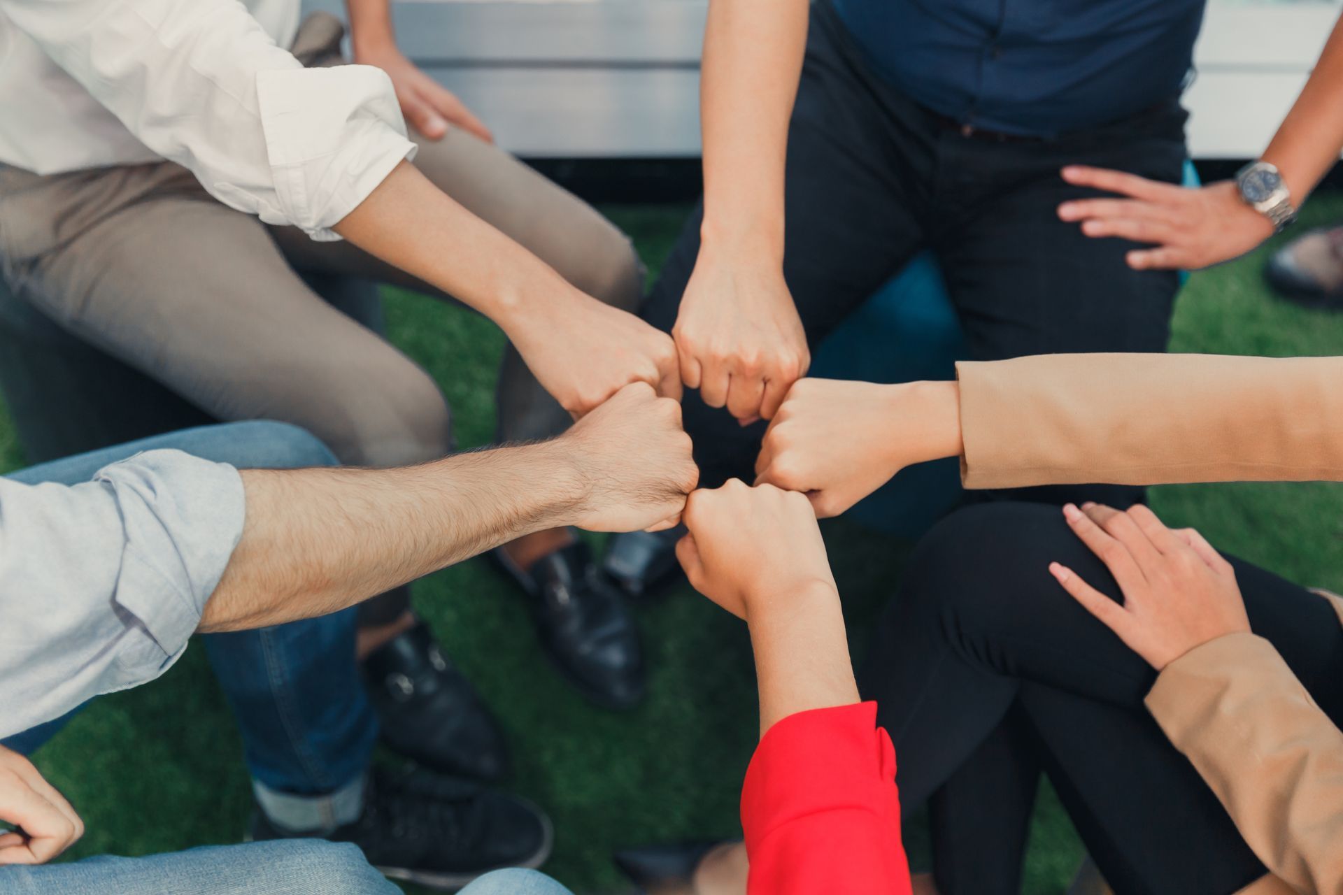 Des poings serrés en cercle, symbolisant le travail d'équipe et la collaboration.