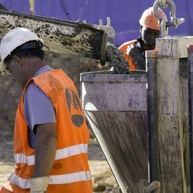 Dos trabajadores de la construcción están trabajando en un sitio de construcción.