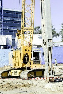Una gran grúa amarilla está trabajando en un sitio de construcción.