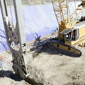 Una gran grúa de construcción está cavando un hoyo en el suelo.