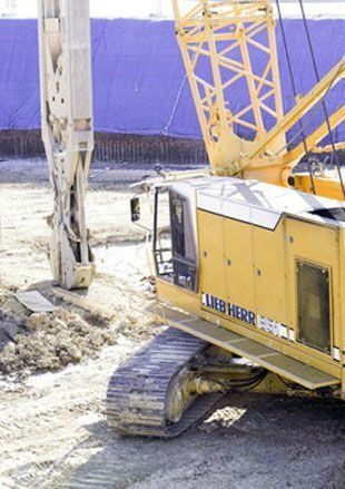 Una excavadora Liebherr amarilla está trabajando en una obra de construcción