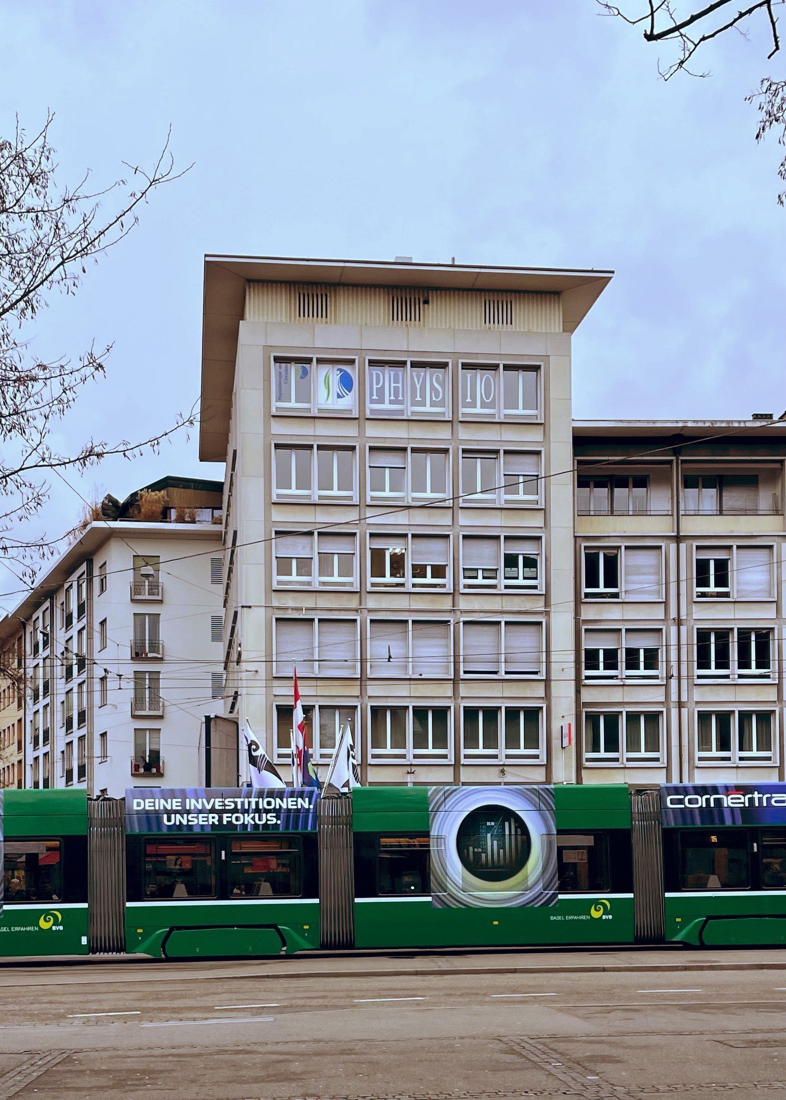 Ein grüner Bus steht vor einem großen Gebäude