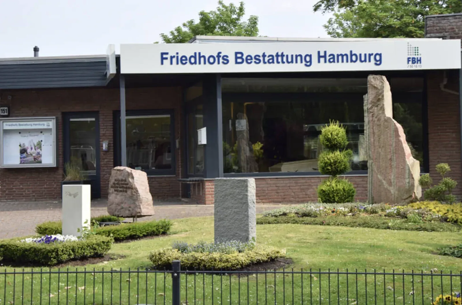 Außenansicht eines Hamburger Bestattungsinstituts mit einem Schild und Steinverzierungen.