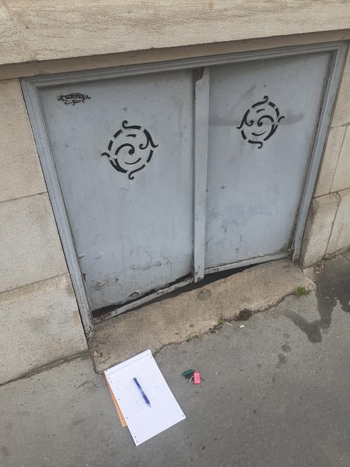 Des portes métalliques grises donnant sur des locaux techniques, encastrées dans un mur de pierre.