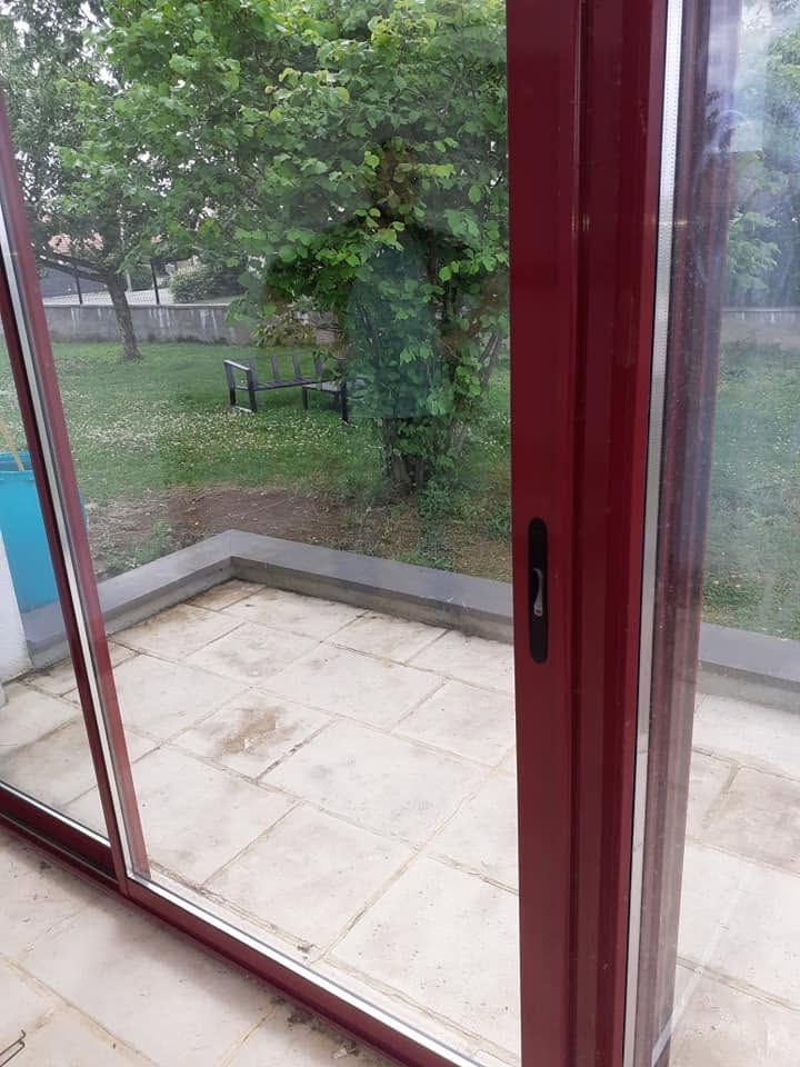 Vue à travers des portes-fenêtres coulissantes encadrées de rouge.