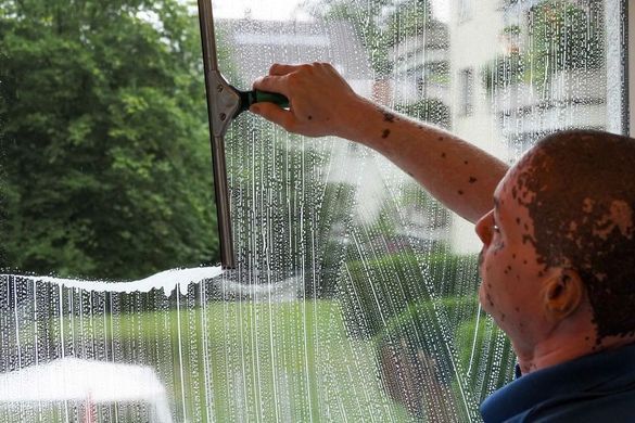 Kenny Messmer von der superReinigung GmbH putzt ein Fenster