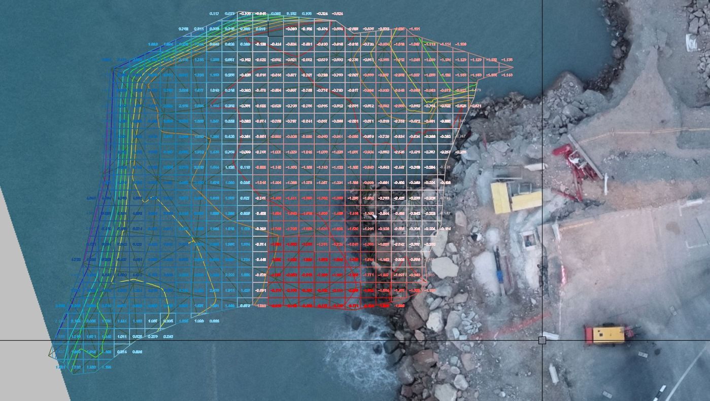 Vista aérea de una cuadrícula de estudio costero. Las líneas de color representan la profundidad del agua, pasando del azul al rojo cerca de la orilla, y se observa una obra en construcción.