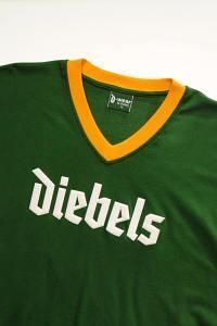 Ein grün-gelbes T-Shirt mit der Aufschrift „Diebels“ darauf.