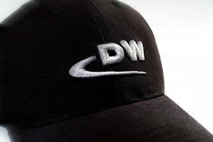 Eine schwarze Baseballkappe mit dem aufgestickten Wort „dw“