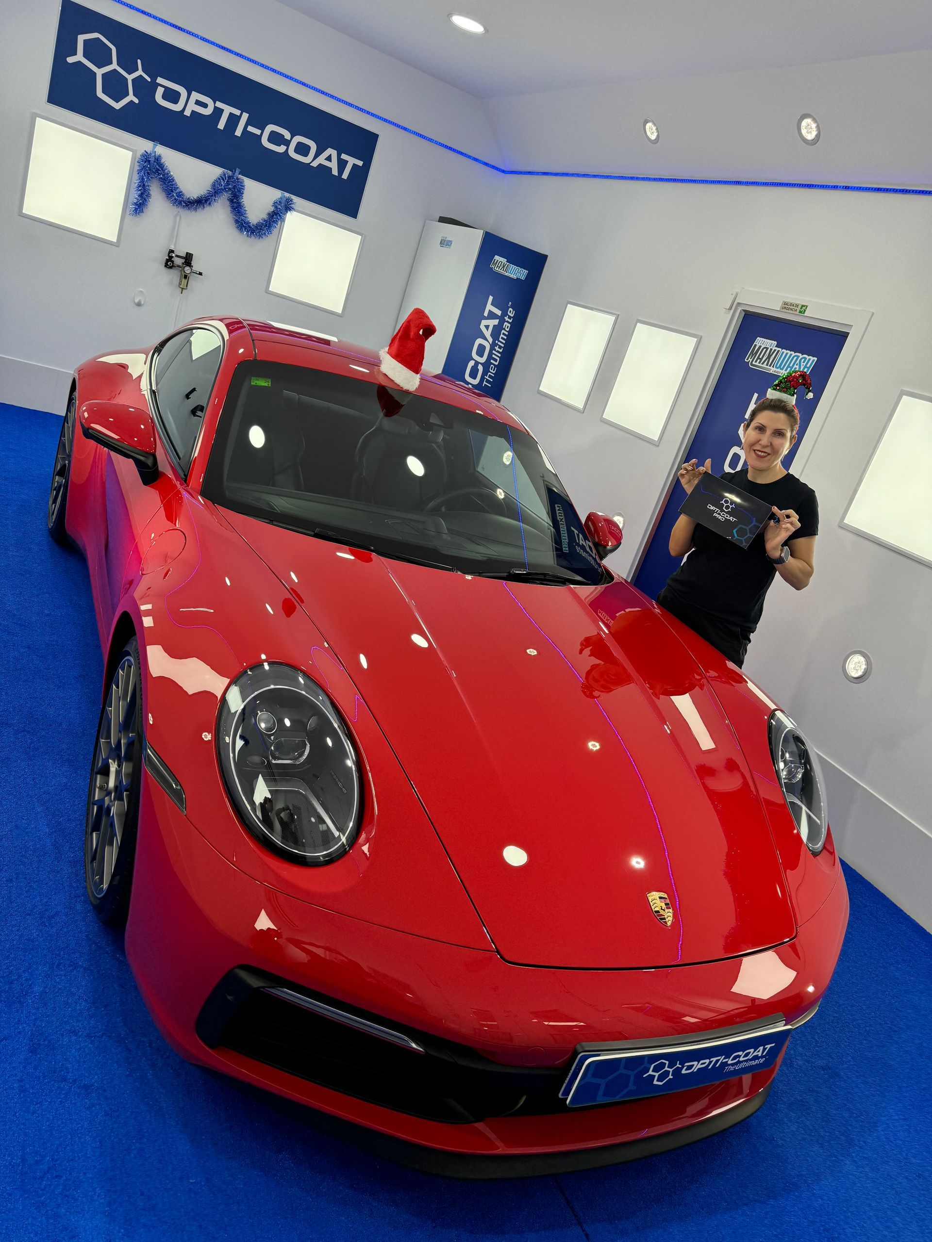 Un hombre está parado frente a un coche deportivo rojo.