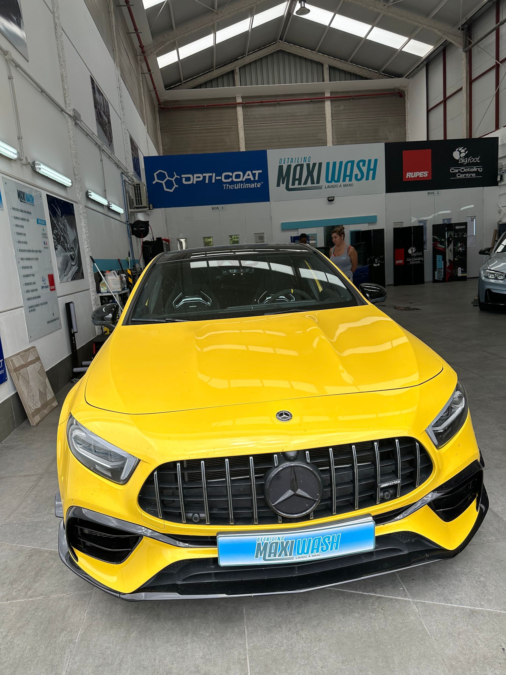 Un Mercedes AMG amarillo está estacionado en un garaje.
