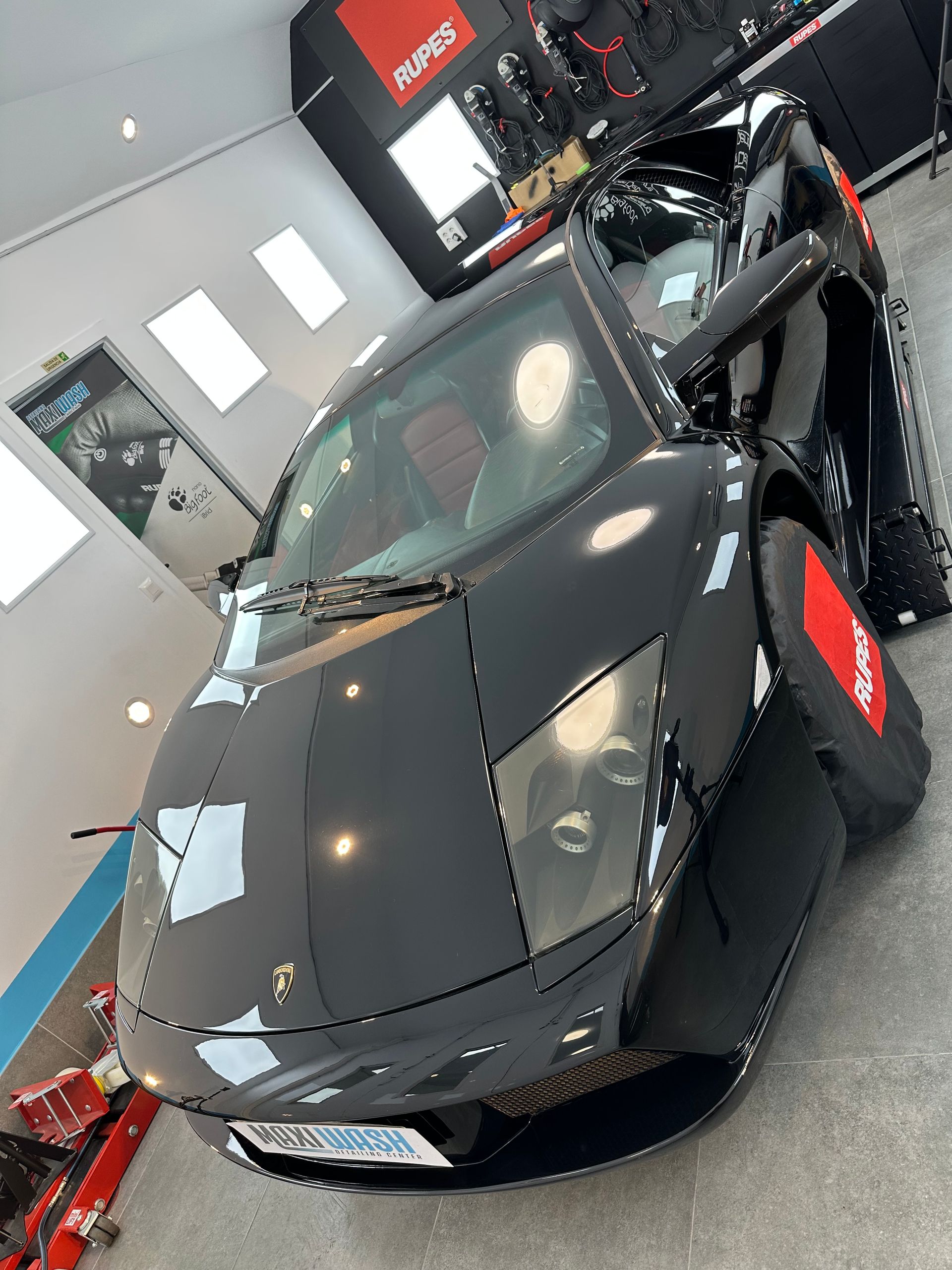 Un coche deportivo negro está aparcado en un garaje.