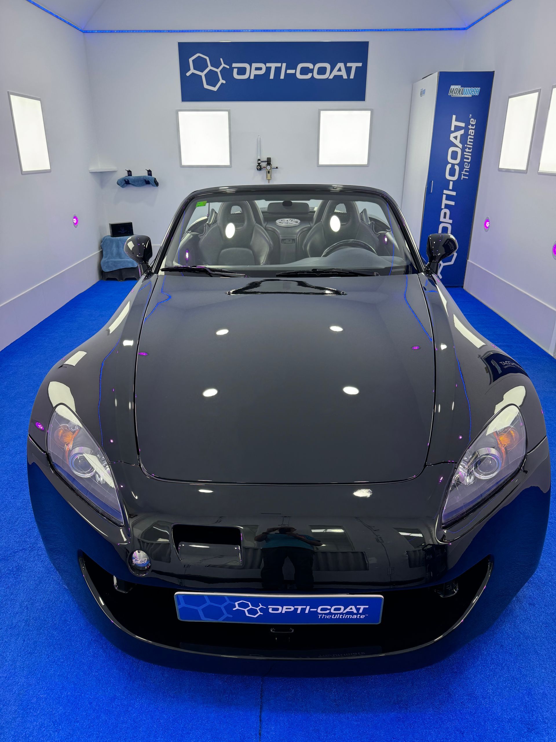 Un coche deportivo negro está aparcado en un garaje.