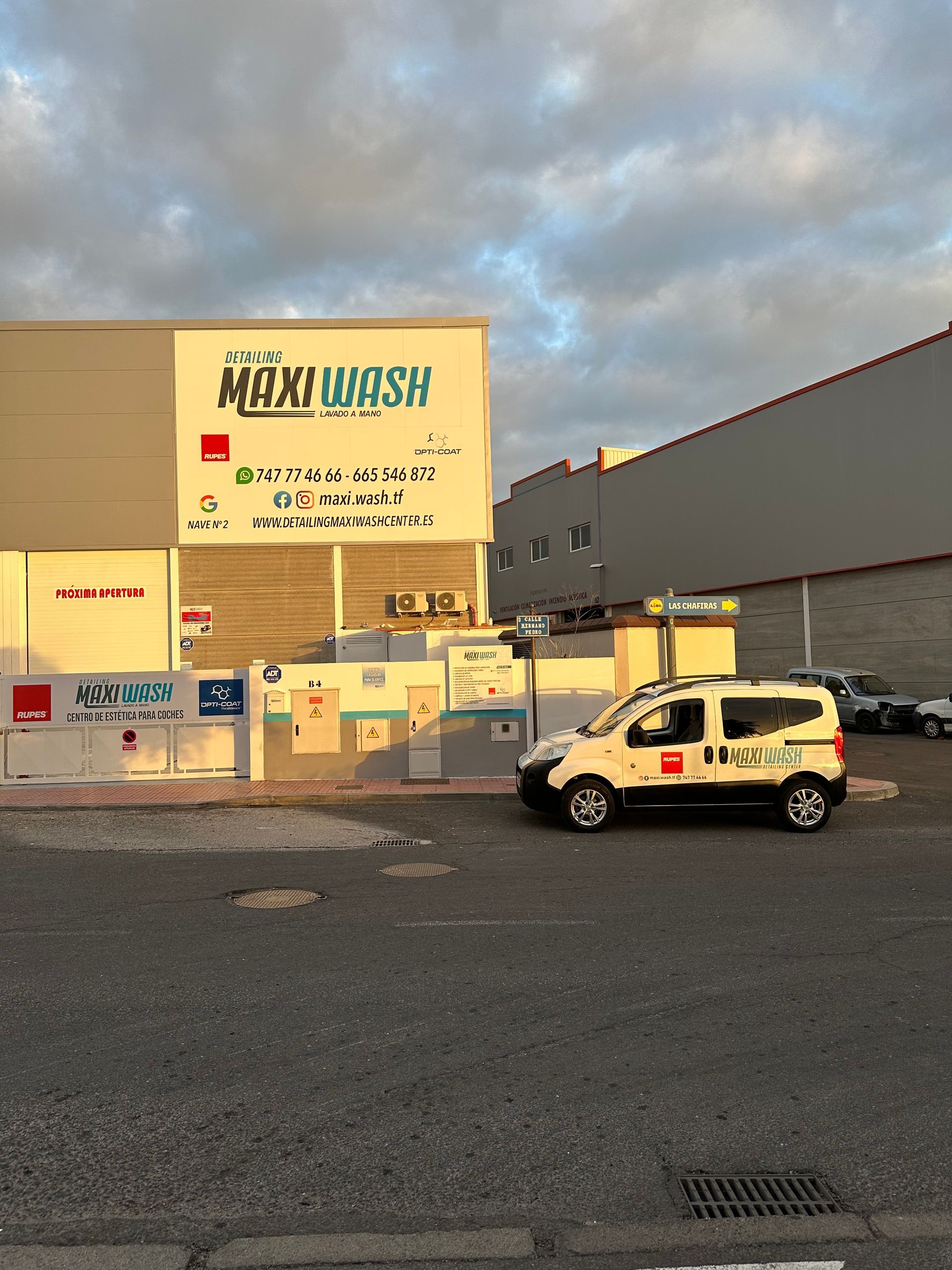 Una camioneta blanca está estacionada frente a un edificio.