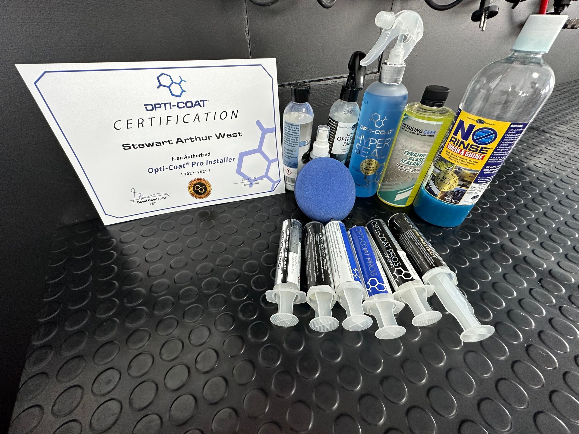 Varias botellas de productos de limpieza y un certificado sobre una mesa.