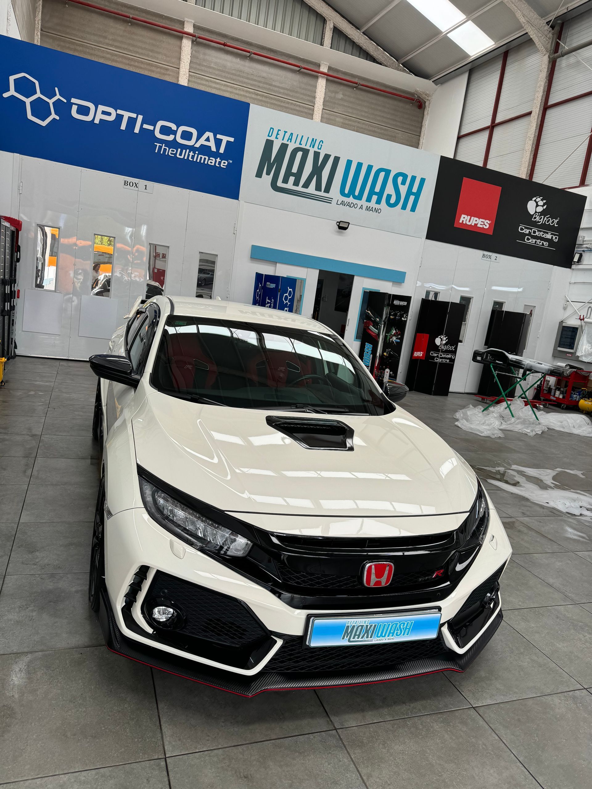 Un Honda Civic Type R blanco está estacionado en un lavadero de autos.