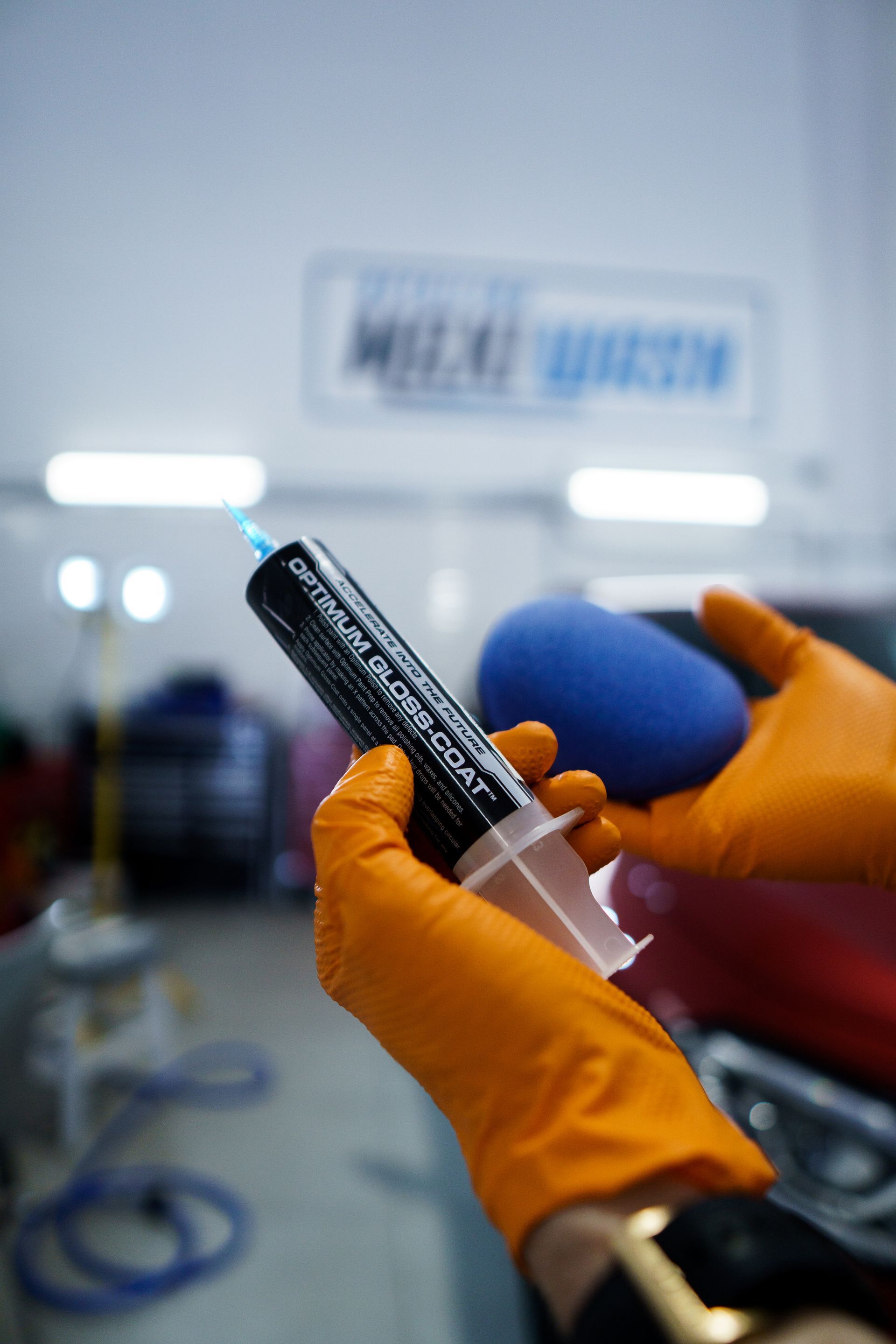 Una persona que lleva guantes naranjas sostiene una jeringa en la mano.
