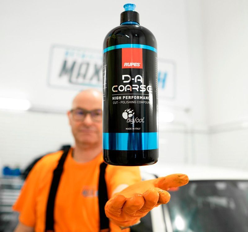 Un hombre sostiene una botella de abrillantador grueso.