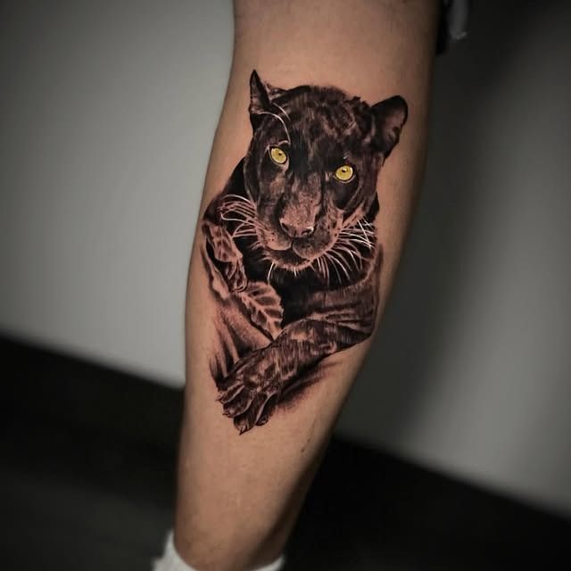 Tatuaje de una pantera negra en la pantorrilla, con ojos amarillos brillantes y líneas rosas