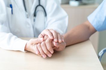 Arzt hält die Hand eines Patienten