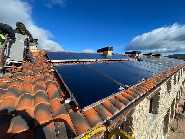 Profesionales instalando placas solares en el tejado de una vivienda en Madrid Sur