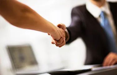 Un hombre y una mujer se dan la mano en una oficina.