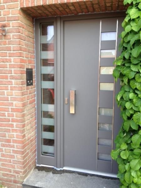 Die Eingangstür eines Backsteinhauses mit einer grauen Tür