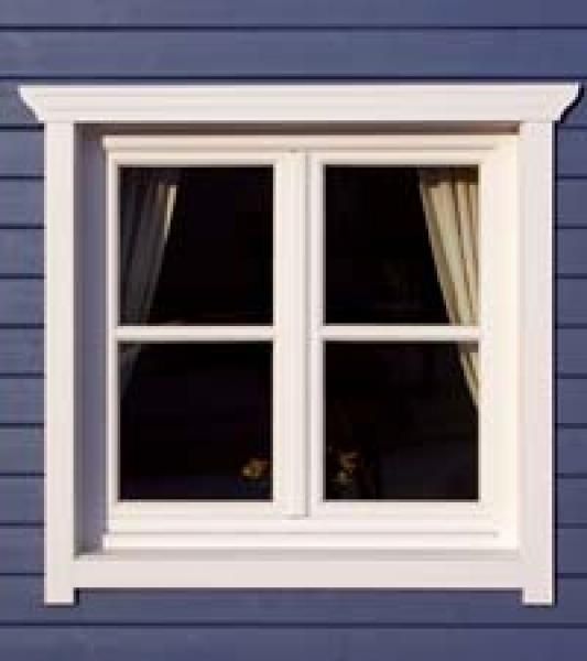 Ein weißes Fenster an einem blauen Haus mit Vorhängen.