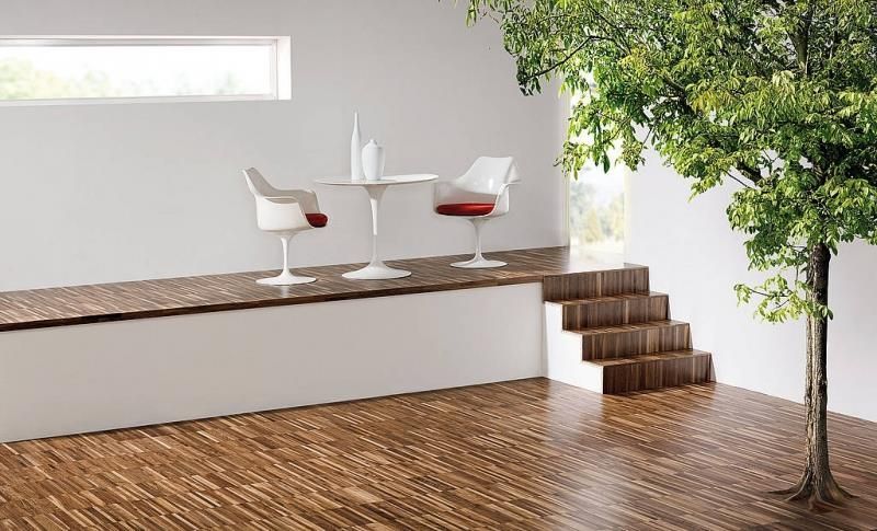 Ein Raum mit einem Tisch und Stühlen und einem Baum in der Mitte