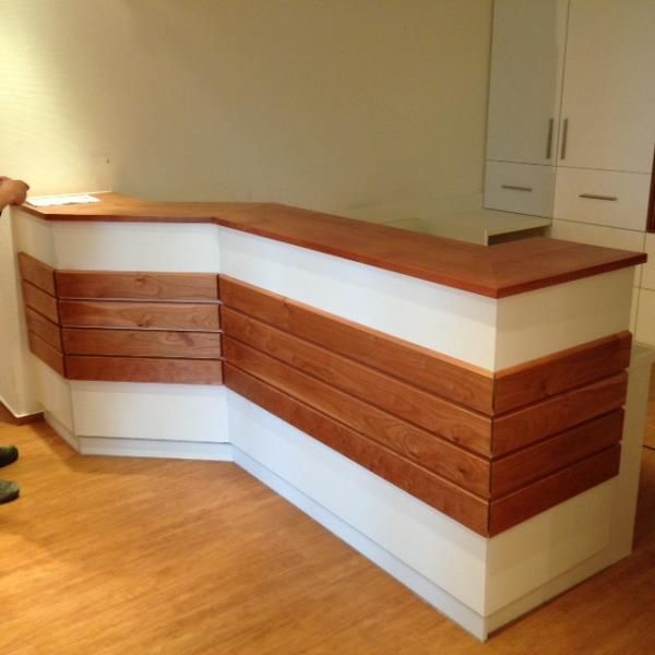 Eine Holztheke in einem Raum mit weißen Schränken