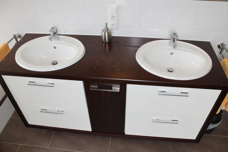 Ein Badezimmerschrank mit zwei Waschbecken und Schubladen