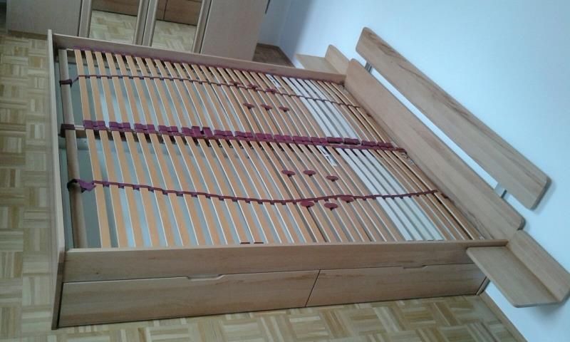 Ein Bett mit Holzrahmen und Lattenrost in einem Schlafzimmer