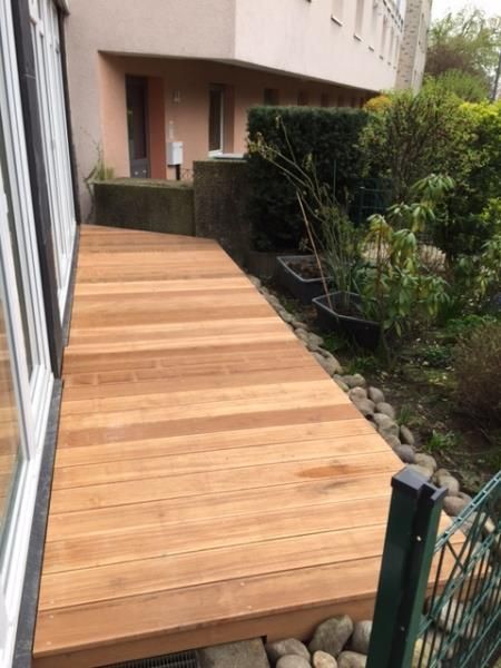 Ein Holzdeck mit einem Haus im Hintergrund