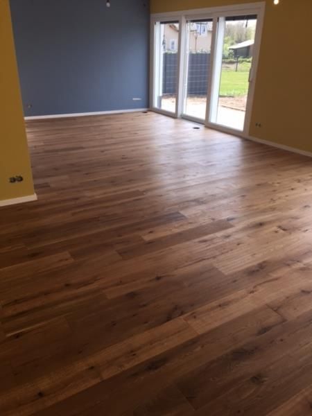 Ein leerer Raum mit Holzboden und Glasschiebetüren