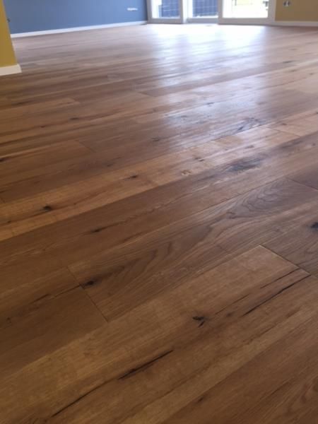 Ein Holzboden in einem leeren Raum mit einer Glasschiebetür.