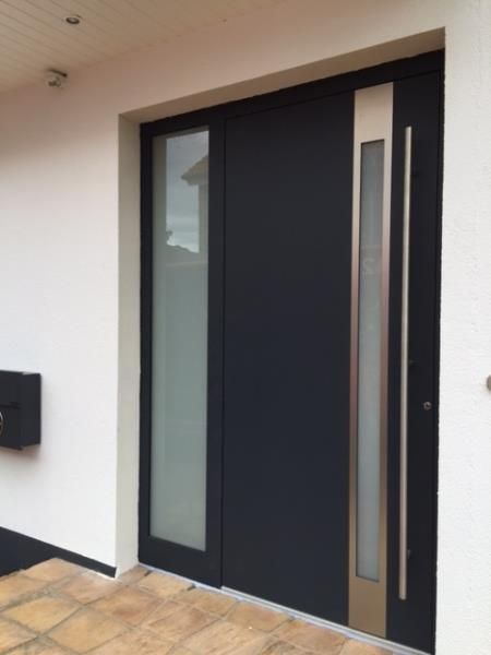 Eine schwarze Tür mit einem Edelstahlgriff